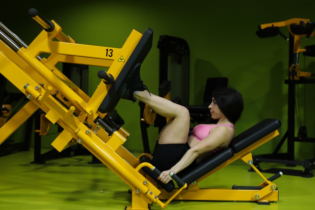 Fit woman in leg press machine 
