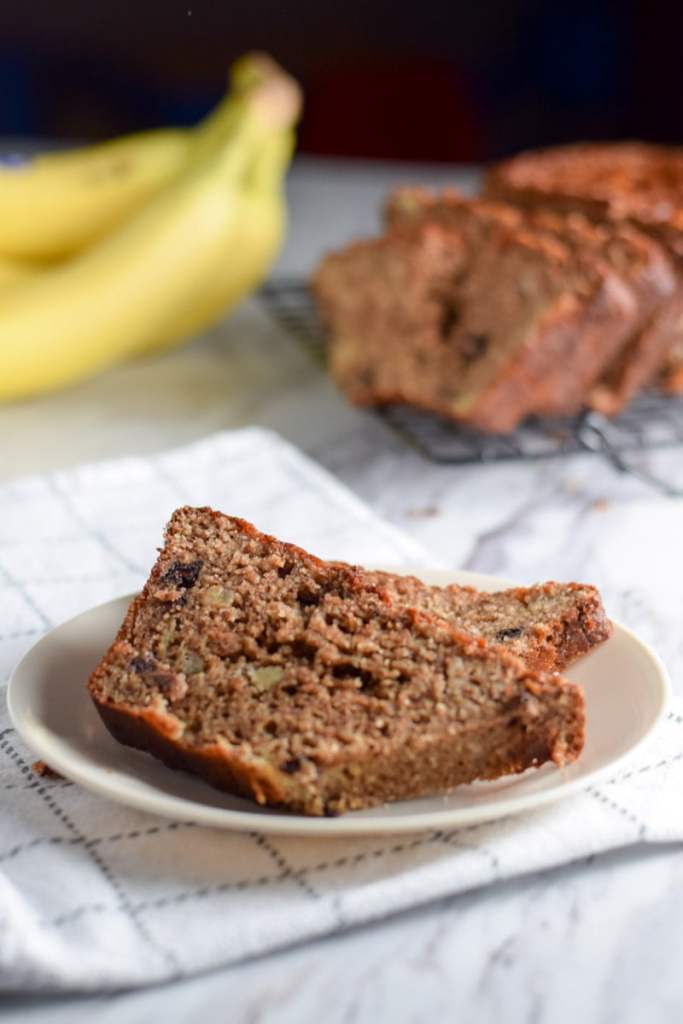 High protein banana bread with bananas in the background 
