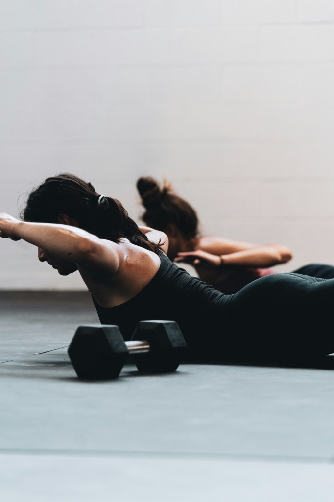 Two women performing Superman exercise 
