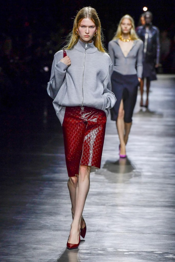 Model wearing red leather skirt and grey sweatshirt