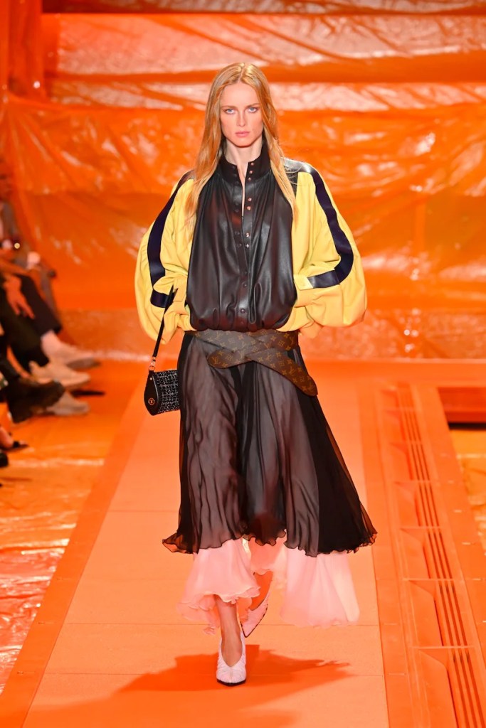 Model wearing sporty jacket and flowy skirt