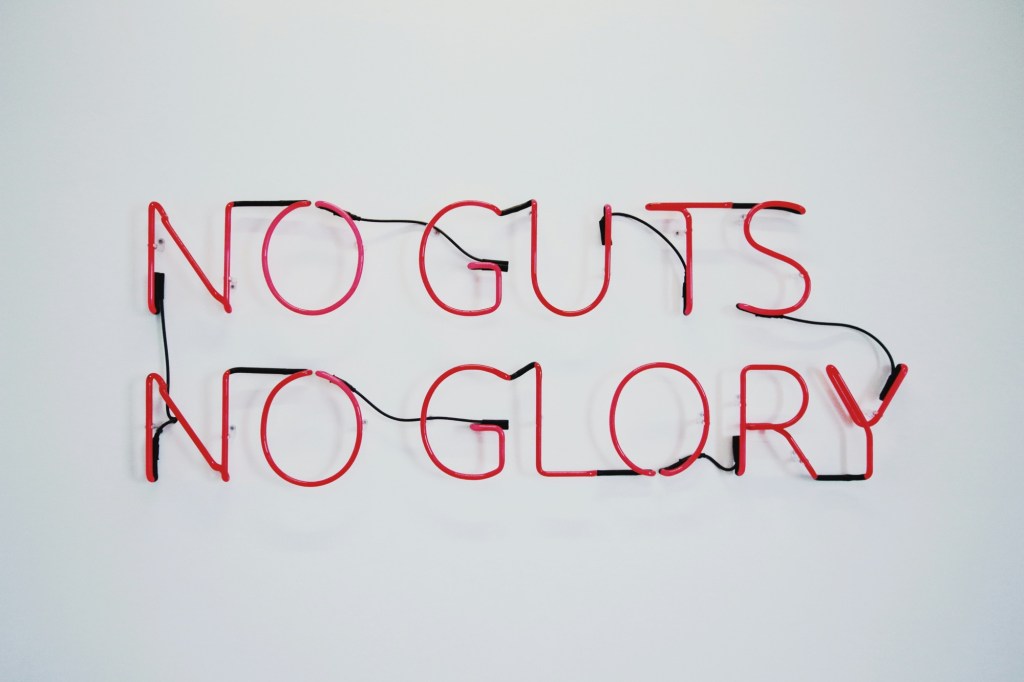 Red sign that says “no guts, no glory” 
