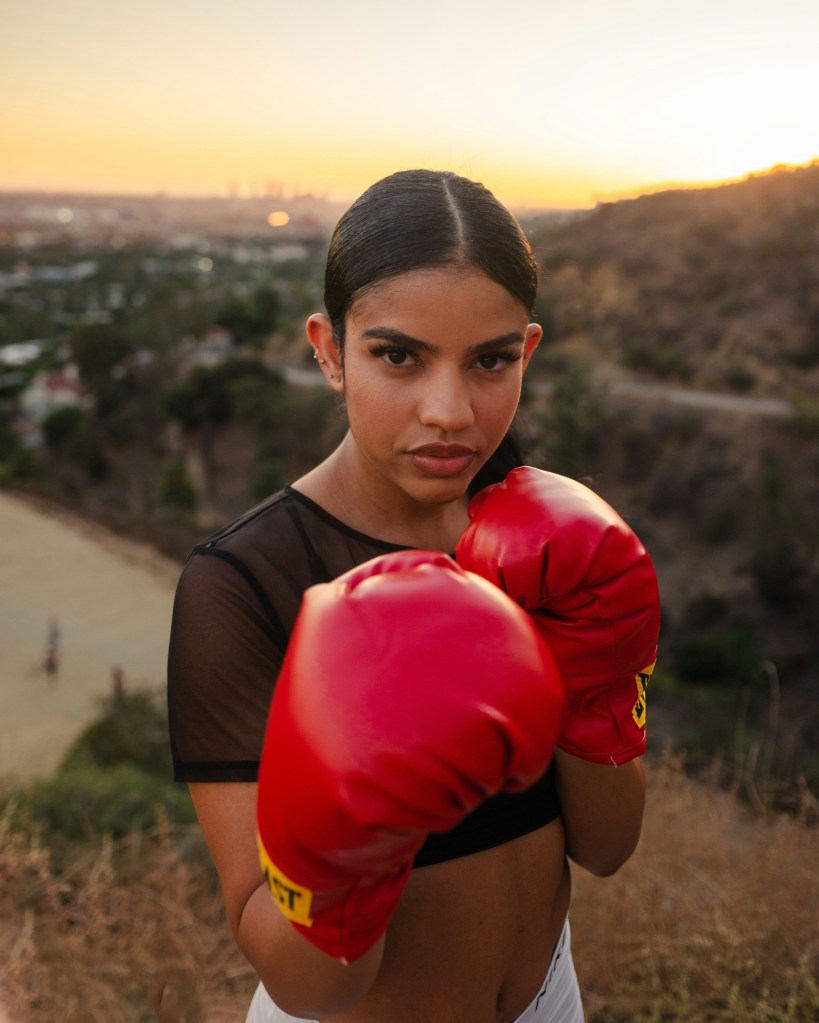 Beautiful woman wearing red punching gloves in a boxing pose 