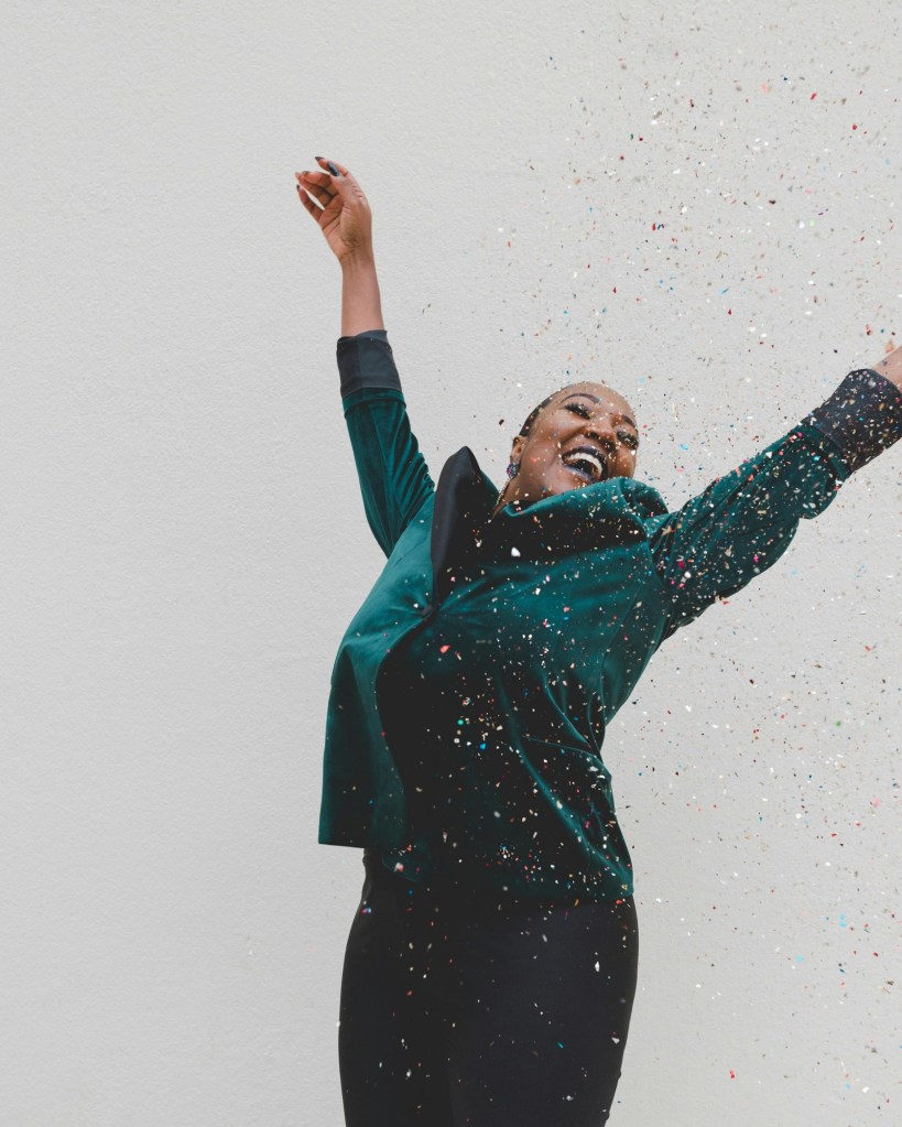 Woman happy and celebrating with confetti in front of her