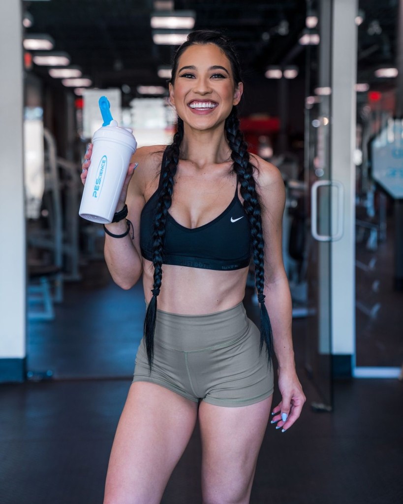 Fitness YouTuber Stephanie Buttermore smiling and drinking protein shake 

