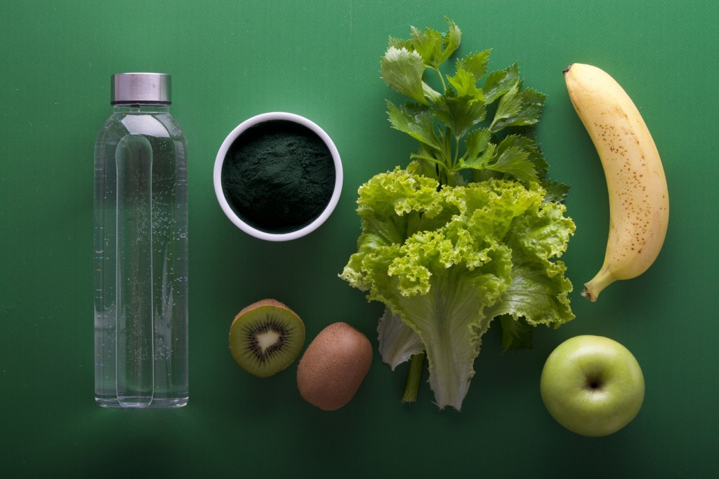 Green fruits and vegetables, banana and water 
